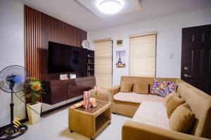a living room with a couch and a tv at Sam's Residence in Marilao