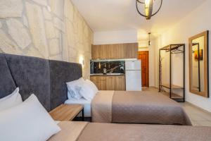 a hotel room with two beds and a kitchen at Μυρτιές-Mirties in Siviri