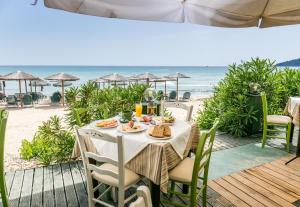 Una mesa en la playa con comida. en Green Sea Apartments, en Skala Potamias