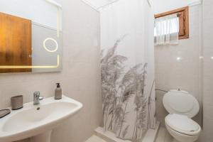 a bathroom with a toilet sink and a shower curtain at Μυρτιές-Mirties in Siviri