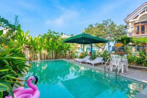 a swimming pool with two pink flamingos in the water at Flamingo Villa Hoi An in Hoi An +54 photos