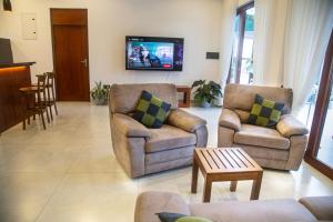a living room with two chairs and a tv at Still Reef in Matara