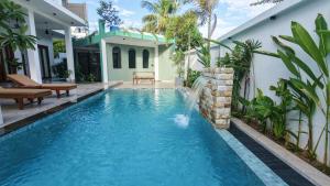 a swimming pool in the backyard of a house with a waterfall at Still Reef in Matara