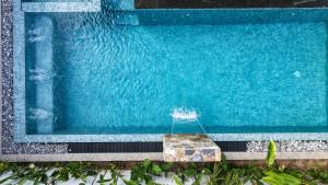 a blue swimming pool with a rock in the water at Still Reef in Matara