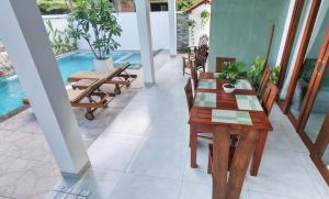 a patio with a table and chairs and a pool at Still Reef in Matara