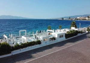 a row of white buildings next to the water at Xenia Suites Duomo in Reggio di Calabria