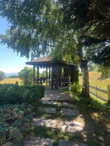 a gazebo in a field with a tree at Aspen Pirin View in Razlog