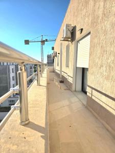an empty sidewalk on a building with a crane in the background at S2 vip nouvelle soukra in Sukrah