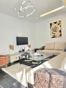 a living room with a couch and a table at S2 vip nouvelle soukra in Sukrah