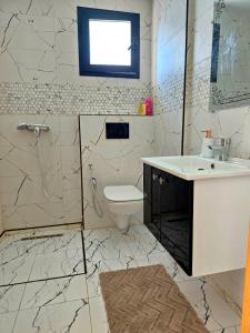 a bathroom with a sink and a toilet and a window at S2 vip nouvelle soukra in Sukrah +4 photos