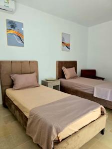 two beds sitting next to each other in a room at S2 vip nouvelle soukra in Sukrah