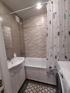 a bathroom with a tub and a sink and a shower curtain at Ткачёва in Pavlodar