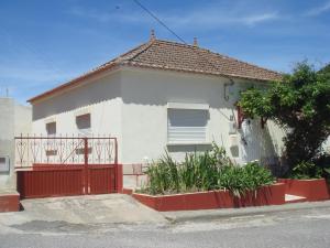 a white and red house with a red gate at Bela Vista in Lourinhã