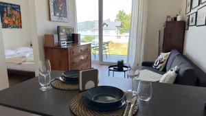 a living room with a table with plates and wine glasses at Hermitage Apartment E03B - Seeblick & Zugang in Maria Wörth