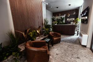 a lobby with leather chairs and a counter in a store at Hôtel Elite in Sion