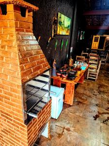 a brick oven in a room with a table at Panorâmic Luxo Exclusiv in Santa Cruz Cabrália