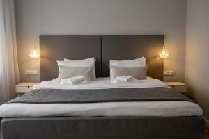 a bedroom with a large bed with white sheets and pillows at Šiaurės Vartai in Joniškis +109 photos