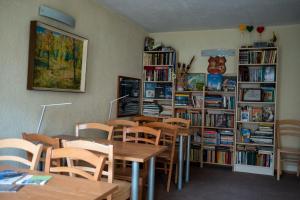 a classroom with tables and chairs and book shelves at Šiaurės Vartai in Joniškis