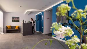 a woman standing at a counter in a waiting room at Šiaurės Vartai in Joniškis