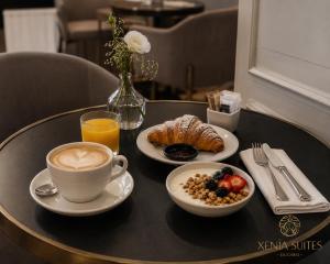a table with a cup of coffee and a plate of food at Xenia Suites Duomo in Reggio di Calabria