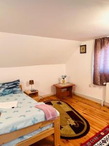 a bedroom with a bed and a wooden floor at Casa Butunoi in Dămuc