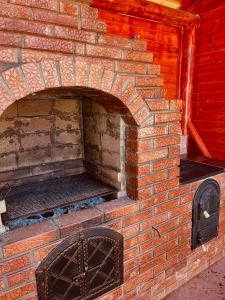 an outdoor brick oven with an open door at Casa Butunoi in Dămuc