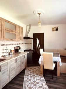 a kitchen with a table and a dining room at Casa Butunoi in Dămuc
