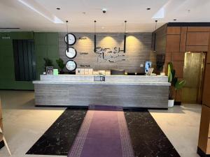 a lobby with a reception counter with clocks on the wall at شقق ثري ستار للشقق المخدومة 5 in Al Kharj