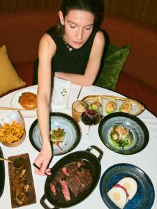 a woman sitting at a table with plates of food at Coeur de Megève in Megève