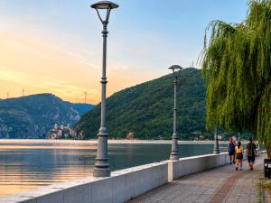 people walking on a sidewalk next to a body of water at Central No1-Apartments in Golubac