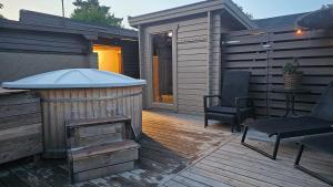 ein Whirlpool auf einer Holzterrasse mit einem Stuhl in der Unterkunft Real holiday feeling with sauna in Beddinge Strand + 13 Fotos