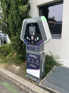 a parking meter sitting on the side of a street at Hôtel Le Palladior Voiron in Voiron