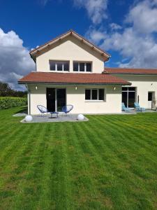 a white house with two chairs in a yard at Suite Romantique in Saint-Romans