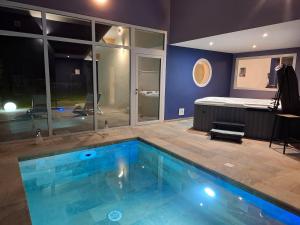 a large swimming pool in a room with a bed at Suite Romantique in Saint-Romans