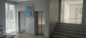 a staircase in a building with a painting on the wall at Apartman RS 27 Апартамент на плажа с вълшебна гледка към морето, напълно оборудвана кухня и безплатен паркинг, със самостоятелен басейн, балкон и асансьор Самостоятелен душ и тоалетна ТОП местоположение in Lozenets