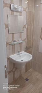 a bathroom with a white sink and a mirror at Apartman RS 27 Апартамент на плажа с вълшебна гледка към морето, напълно оборудвана кухня и безплатен паркинг, със самостоятелен басейн, балкон и асансьор Самостоятелен душ и тоалетна ТОП местоположение in Lozenets +9 photos