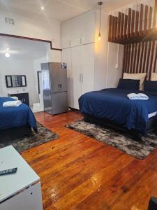 a bedroom with two beds and a refrigerator at Ludiz Self Catering Accommodation in Avondale +80 photos