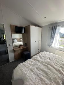 a bedroom with a large white bed and a window at Atlantic Breeze, Mullacott Park in West Down