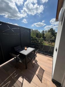 a table and chairs on a balcony with a view at Au fil de la Blies in Bliesbruck