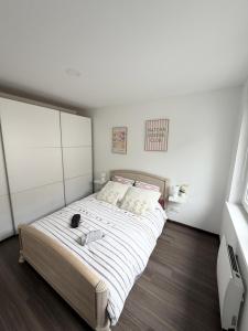a bedroom with a large bed with white sheets at Au fil de la Blies in Bliesbruck