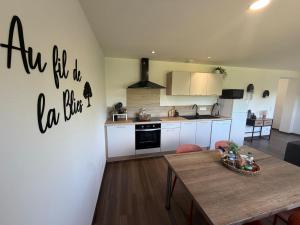 a kitchen with a table and a dining room at Au fil de la Blies in Bliesbruck
