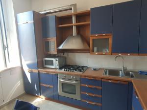 a kitchen with blue cabinets and a stove and microwave at Casa Mane in Avezzano