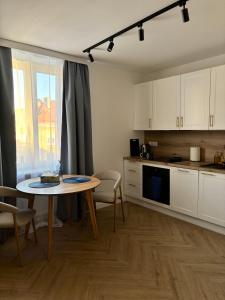 a kitchen with a table and a dining room at WOW Apartament in Białystok +3 photos
