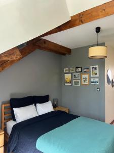 a bedroom with a blue bed and wooden ceilings at Duplex de charme en centre ville avec terrasse in Brive-la-Gaillarde