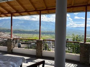 a room with a balcony with a view of mountains at Stone Pazar Guest House in Gjirokastër