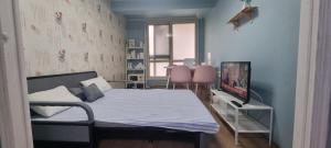a bedroom with a bed and a tv in it at Liz House in Incheon