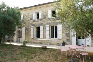 a house with a table and chairs in the yard at Maison Flora Saint Jean d'Angely in Vervant