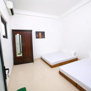 a white room with two beds and a mirror at My Peaceful House Ninh Bình in Phúc Trì