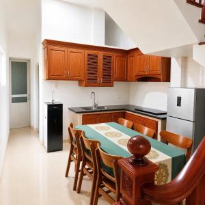 a kitchen with a table and some wooden cabinets at My Peaceful House Ninh Bình in Phúc Trì