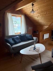 a living room with a couch and a table at Lysbøen Bua in Ramberg